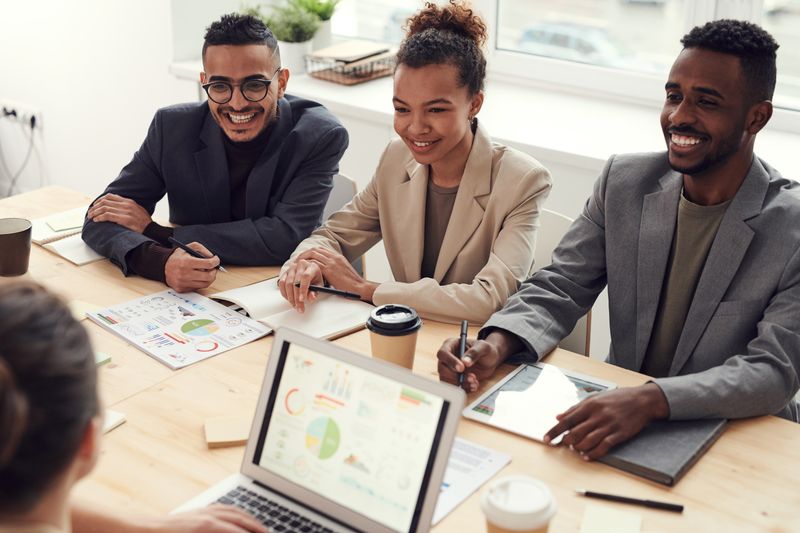 Technology consultants collaborating around a laptop during a client engagement